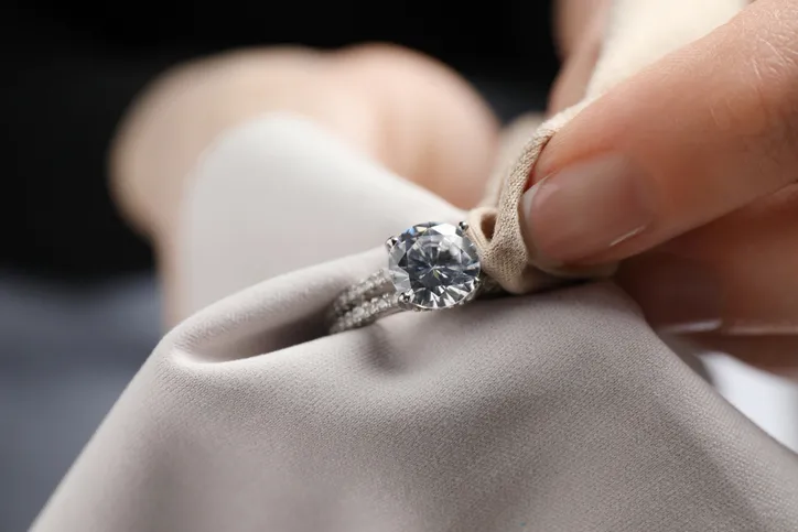 A close-up of a diamond ring being polished or cleaned.