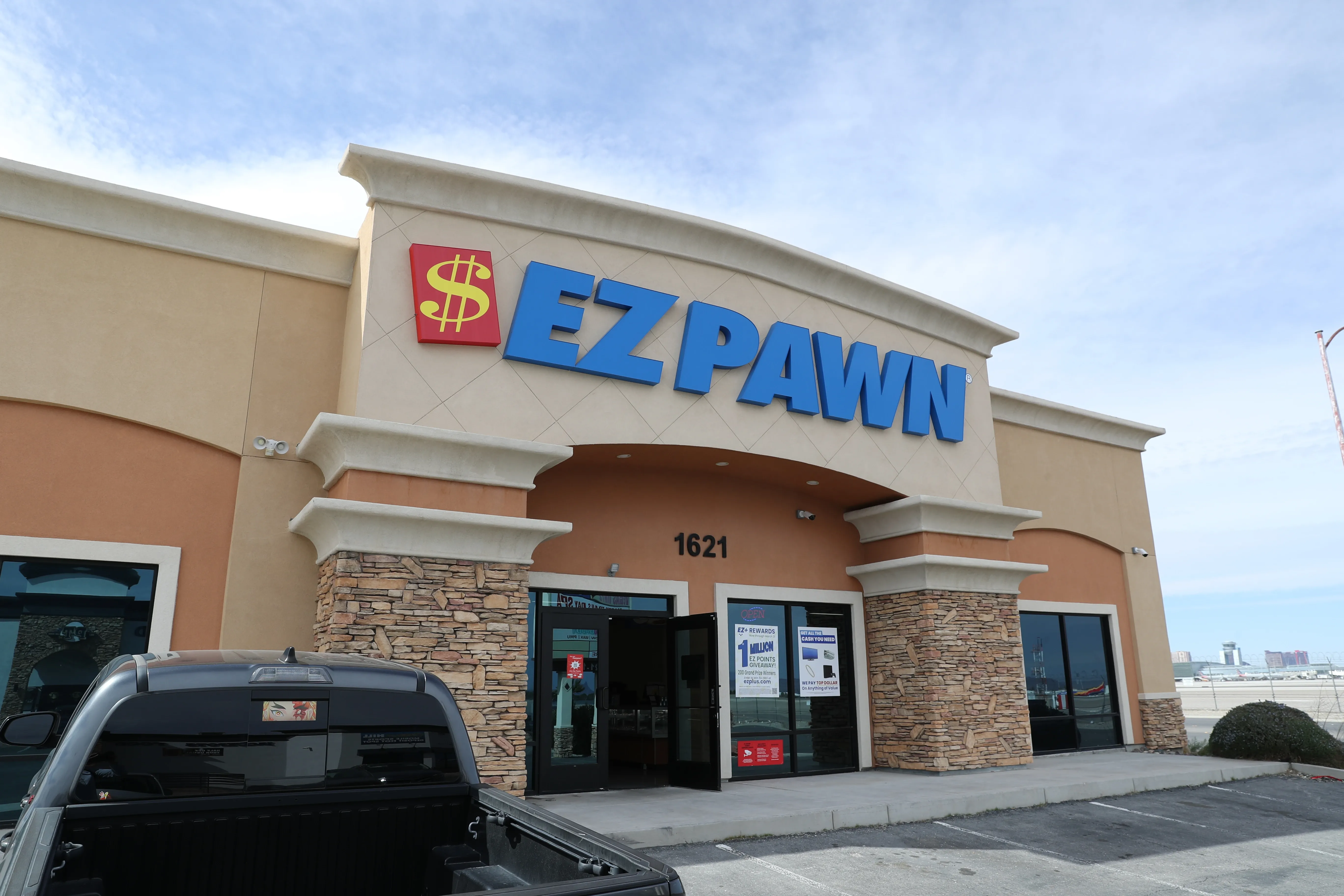 A picture of an EZPAWN store with a truck parked in the parking lot.