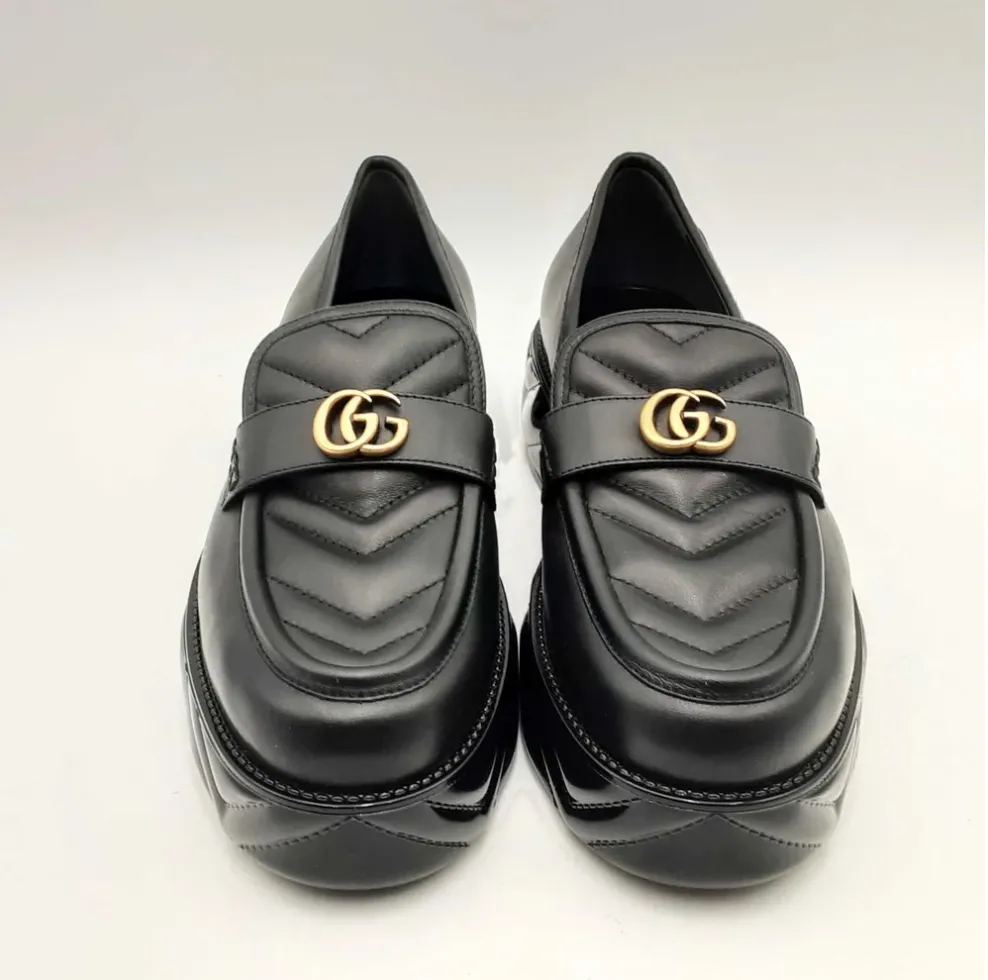 Black leather Gucci loafers with gold hardware.