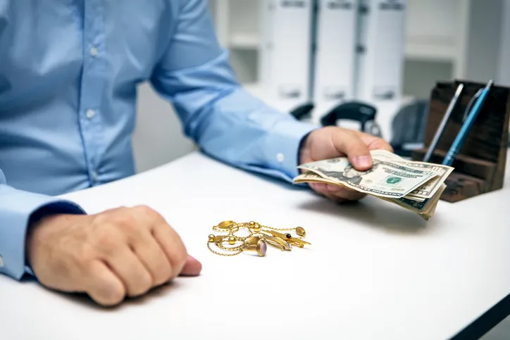 An EZPAWN team member is offering a customer a cash loan for their jewelry.