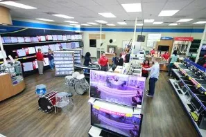 A picture of the inside of the EZPAWN store with team members and customers browsing items, pawing, selling, and buying.