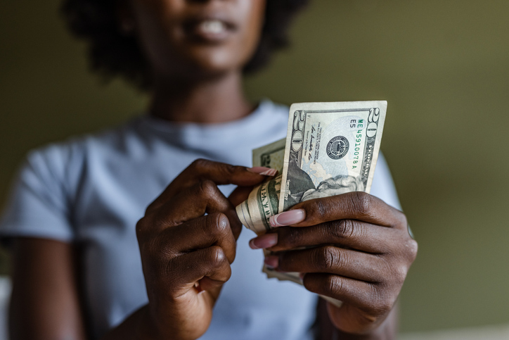 A black woman counting cash.